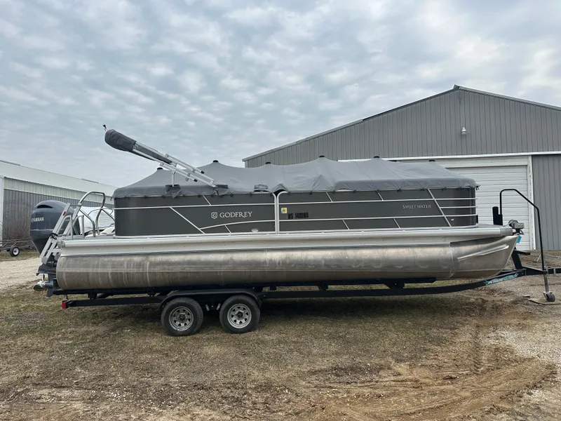 Slide: The Image of 2021 Godfrey Sweetwater 2486 SB pontoon boat on trailer, covered and parked outdoors. - 7