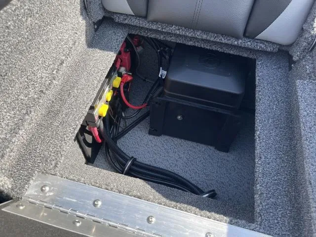 Slide: The Image of 2025 Lund 2075 Pro-V Sport boat battery compartment with wiring and secure cover. - 11