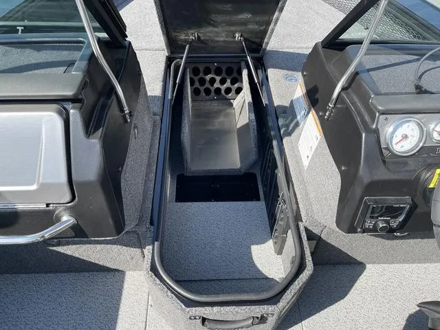 Slide: The Image of 2025 Lund 2075 Pro-V Sport boat interior with open storage compartment and dashboard view. - 14