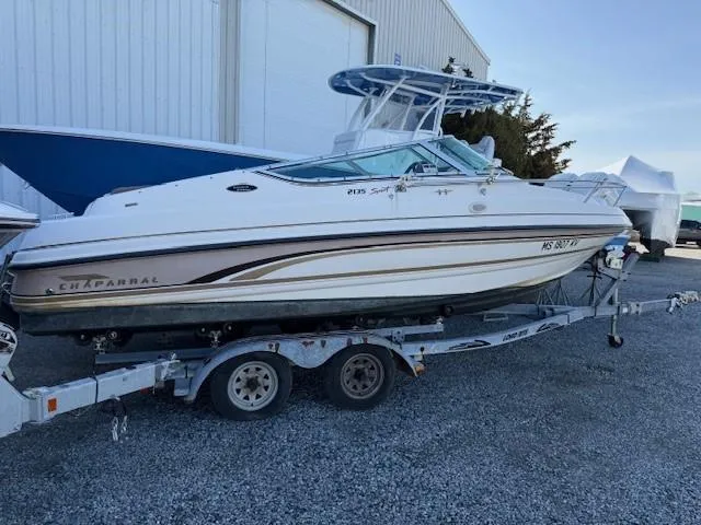 Slide: The Image of 1999 Chaparral 2135 SS boat on trailer, parked outdoors near a building. - 2
