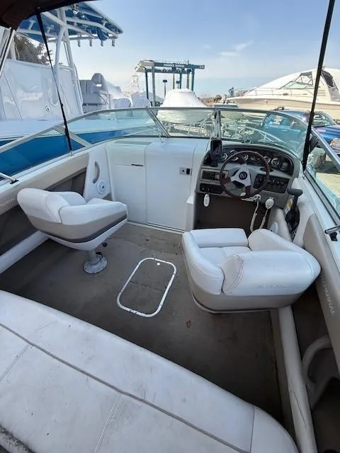 Slide: The Image of 1999 Chaparral 2135 SS boat interior with white seating and steering console. - 9
