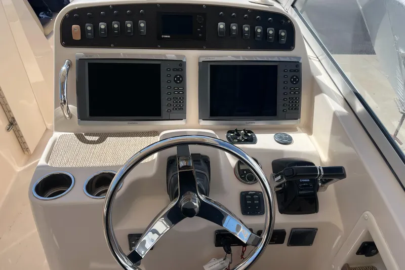 Slide: The Image of 2013 Grady-White Freedom 307 boat dashboard with dual screens and steering wheel. - 10