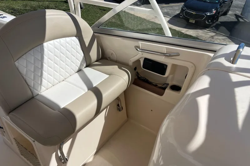 Slide: The Image of 2013 Grady-White Freedom 307 boat interior with beige seating and storage compartment. - 11