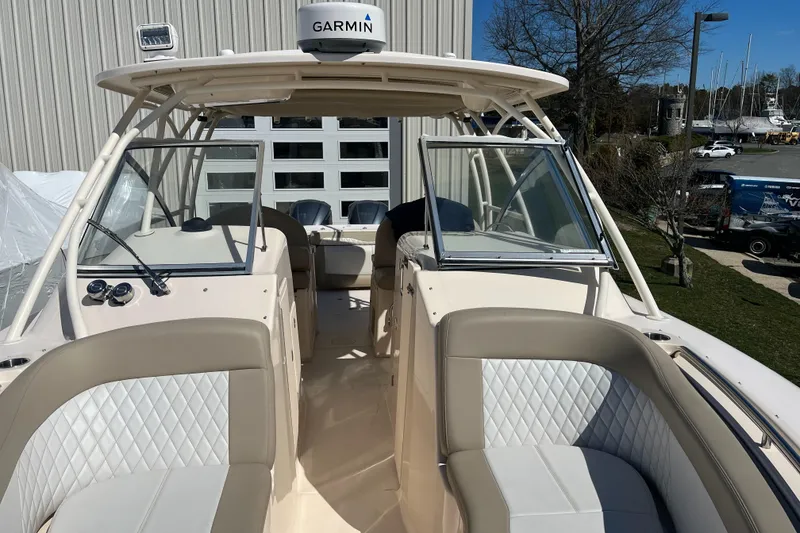 Slide: The Image of 2013 Grady-White Freedom 307 boat interior with Garmin equipment, featuring cushioned seating and open cockpit. - 13