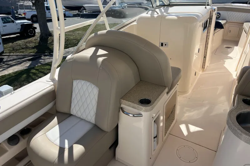Slide: The Image of 2013 Grady-White Freedom 307 boat interior with beige seating and cup holder. - 15