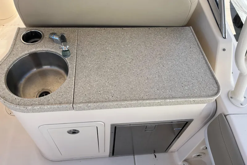 Slide: The Image of 2013 Grady-White Freedom 307 boat kitchenette with sink and storage. - 20