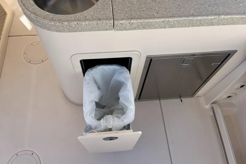 Slide: The Image of Built-in trash bin on 2013 Grady-White Freedom 307 boat, next to a stainless steel sink. - 24