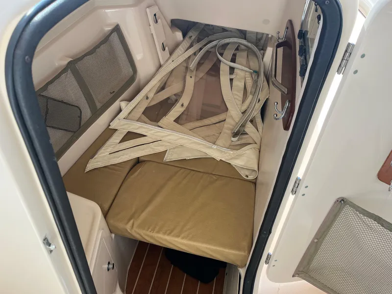 Slide: The Image of 2013 Grady-White Freedom 307 cabin interior with folded canvas and storage compartments. - 27