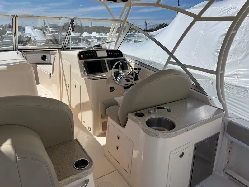 Slide: The Image of 2013 Grady-White Freedom 307 boat interior with helm, seating, and cup holders. - 9