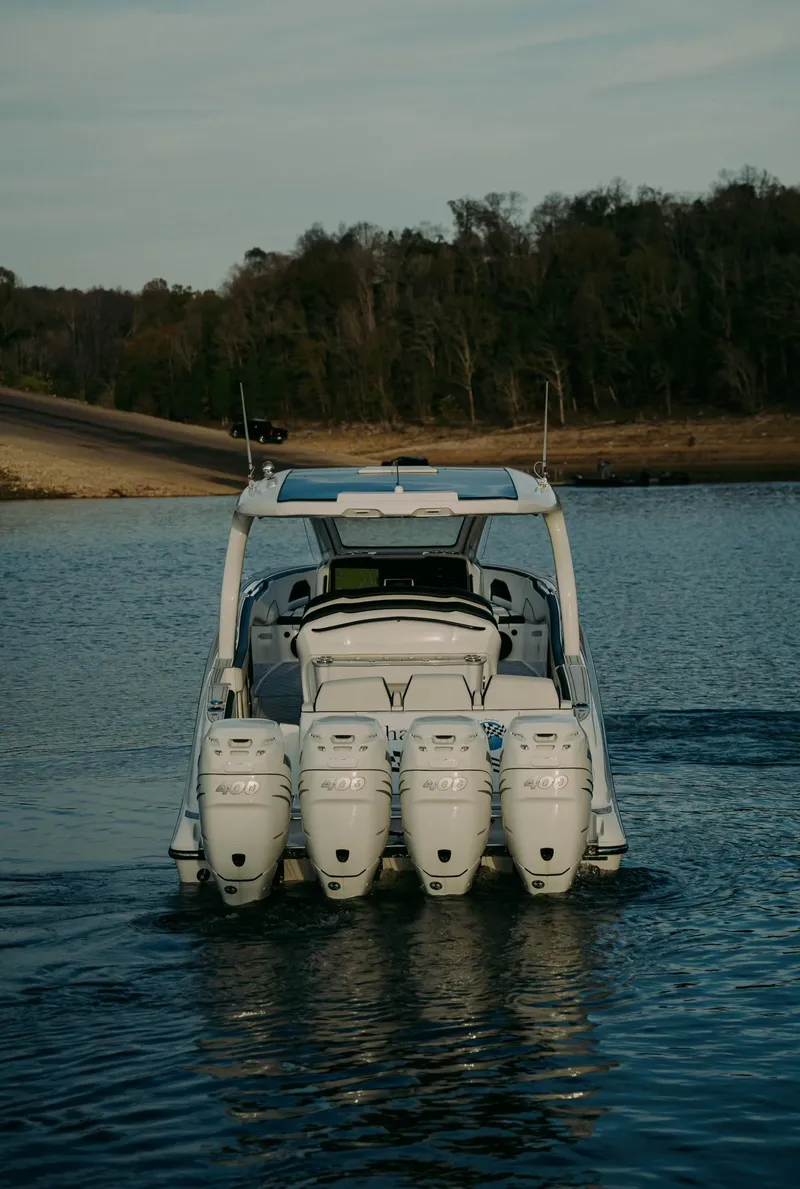 Slide: The Image of 2021 Deep Impact 399 Sport boat with four engines on a calm lake. - 26