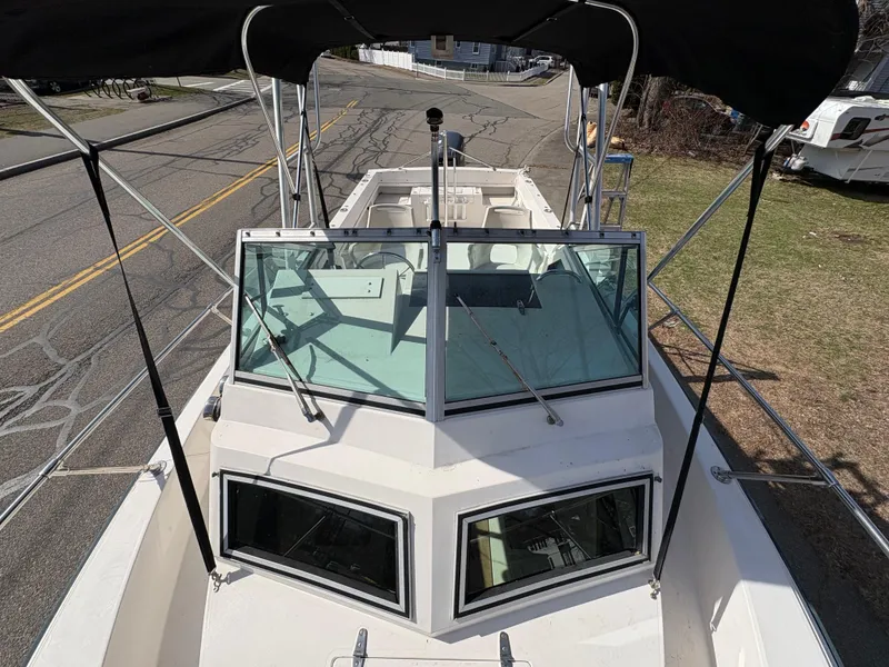 Slide: The Image of 1988 Grady-White 22 Seafarer boat with windshield and canopy, parked on roadside. - 13