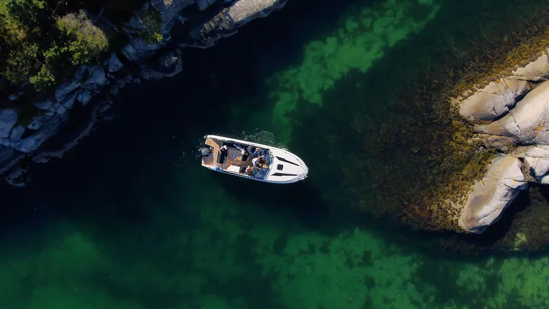 Slide: The Image of Aerial view of 2022 Parker Poland 850 Voyager boat on clear green water near rocky shore. - 10