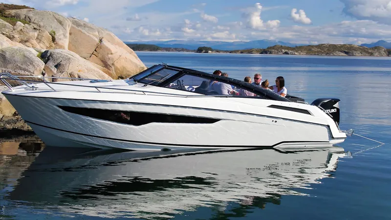 Slide: The Image of 2022 Parker Poland 850 Voyager boat cruising on a serene lake with rocky shoreline. - 9