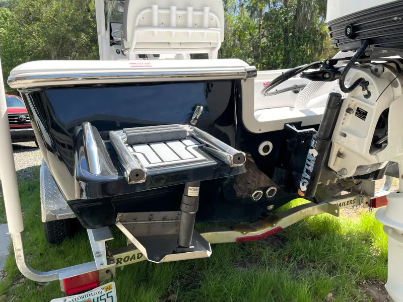 Slide: The Image of 2020 Tidewater 2300 Carolina Bay boat rear view with ladder and motor, parked on grass. - 12