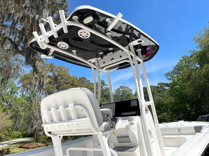Slide: The Image of 2020 Tidewater 2300 Carolina Bay boat with T-top and rod holders, set against a clear sky. - 21