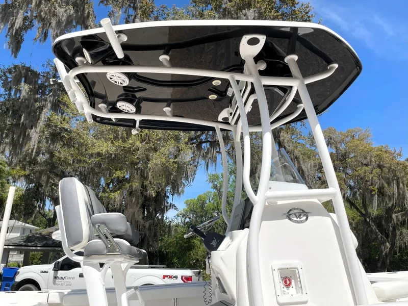 Slide: The Image of 2020 Tidewater 2300 Carolina Bay boat with T-top and seating, under clear blue sky. - 22