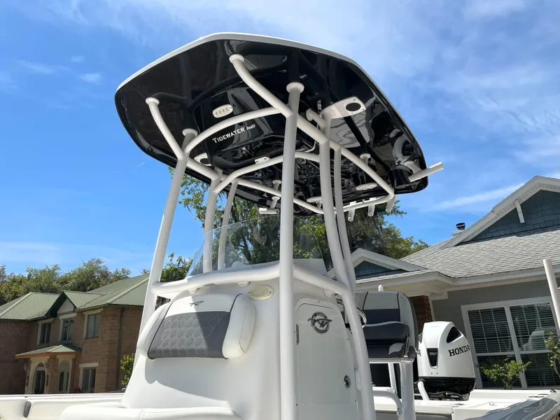 Slide: The Image of 2020 Tidewater 2300 Carolina Bay boat with T-top, parked near residential homes. - 23