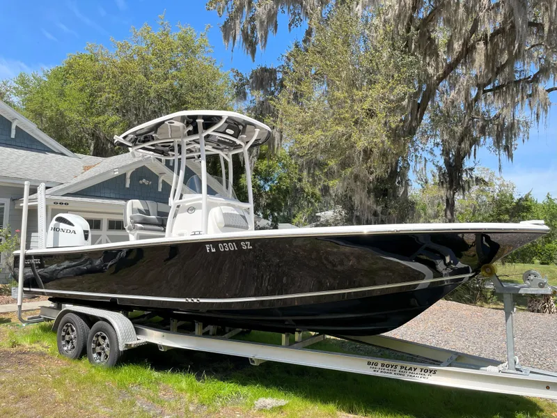Slide: The Image of 2020 Tidewater 2300 Carolina Bay boat on trailer, parked outdoors near trees and house. - 4