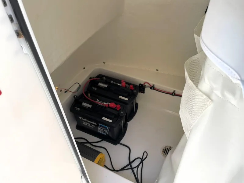 Slide: The Image of 2020 Tidewater 2300 Carolina Bay boat battery compartment with dual batteries and wiring. - 40