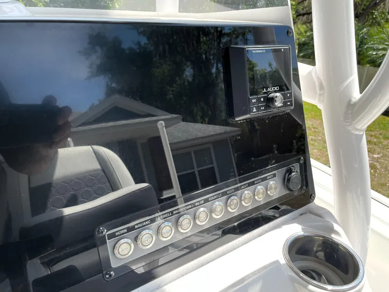 Slide: The Image of 2020 Tidewater 2300 Carolina Bay boat dashboard with control panel and cup holder. - 48