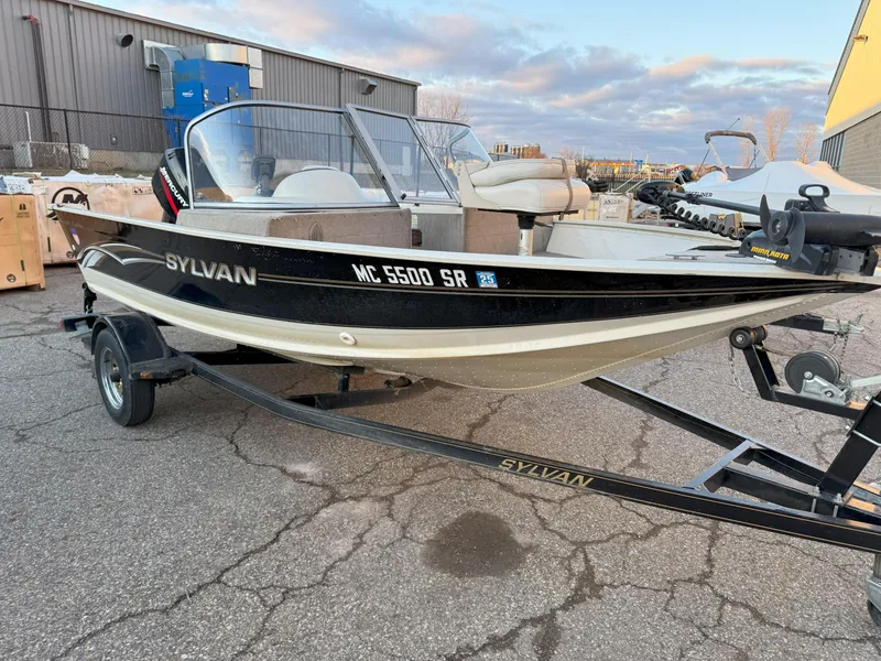 Slide: The Image of 2004 Sylvan 1600 Explorer DC boat on trailer, parked outdoors. - 0