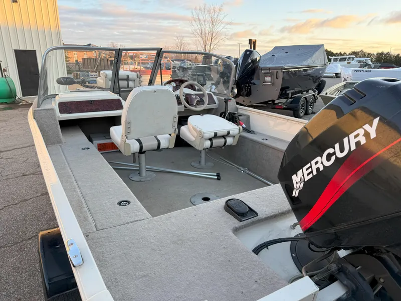 Slide: The Image of 2004 Sylvan 1600 Explorer DC boat with Mercury outboard motor, docked outdoors. - 5