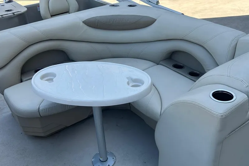 Slide: The Image of Luxurious seating area on 2019 Sylvan 8520 Mirage F-n-C pontoon boat with table and cup holders. - 8