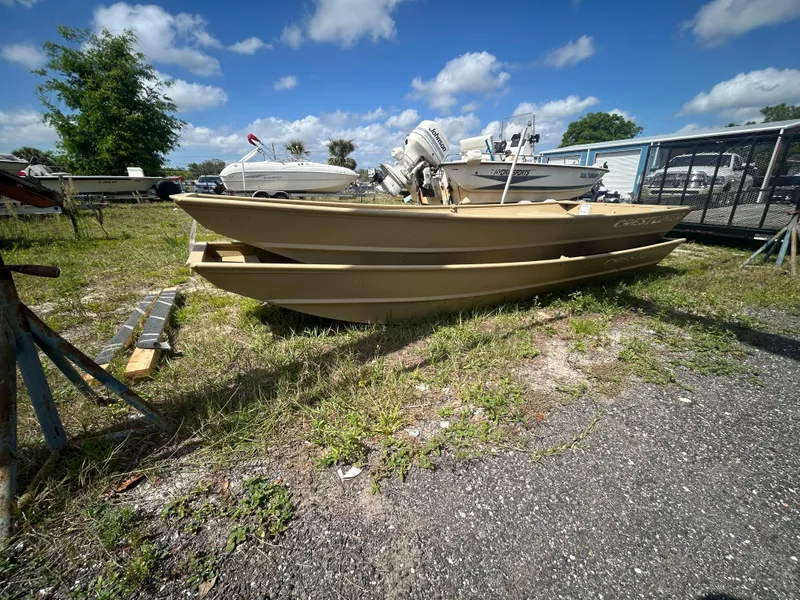 Slide: The Image of 2025 Crestliner CR1436L boat on grass, sunny day, blue sky, other boats in background. - 12