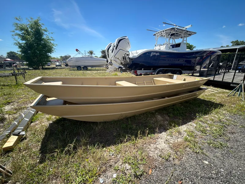 Slide: The Image of 2025 Crestliner CR1436L boats stacked outdoors on grass, with other boats in the background. - 3