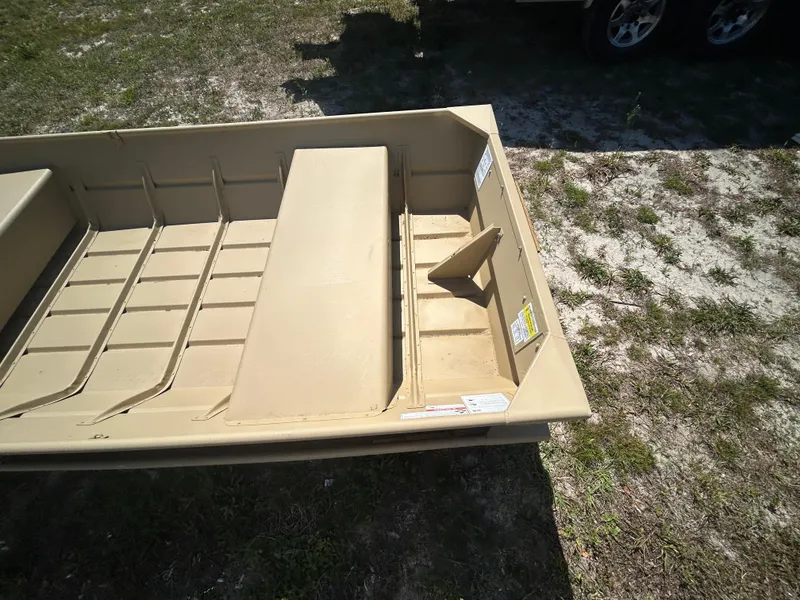 Slide: The Image of 2025 Crestliner CR1436L boat on grass, showcasing interior seating and storage. - 6