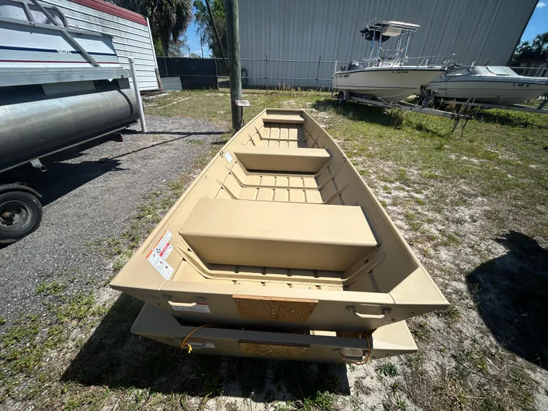Slide: The Image of 2025 Crestliner CR1436L boat, beige color, parked outdoors on grass and gravel. - 7