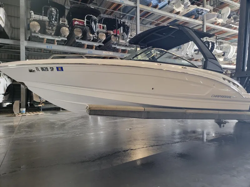 Slide: The Image of 2019 Chaparral 237 SSX boat in storage, sleek design, white exterior, indoor facility. - 3