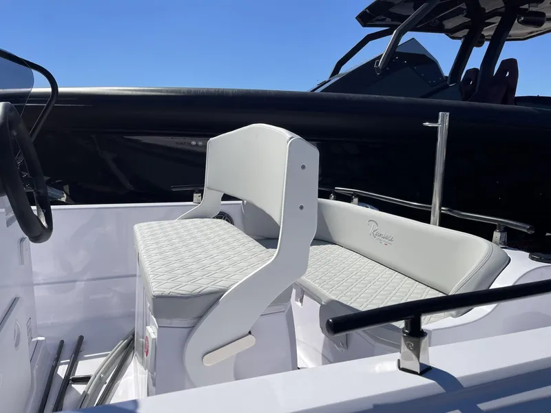 Slide: The Image of 2024 Ranieri Voyager 19S boat with steering console and seating, docked under clear blue sky. - 19