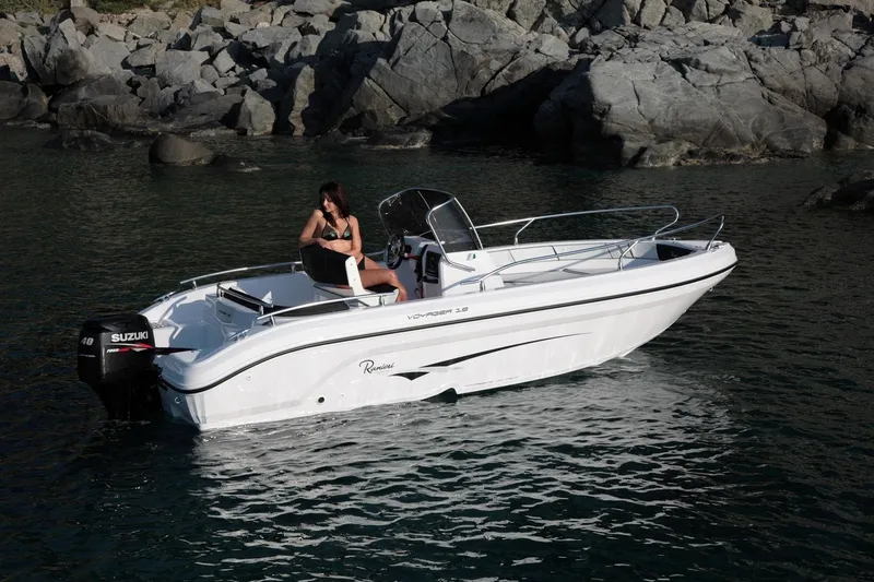 Slide: The Image of 2024 Ranieri Voyager 19S boat on trailer, parked in marina under clear blue sky. - 2