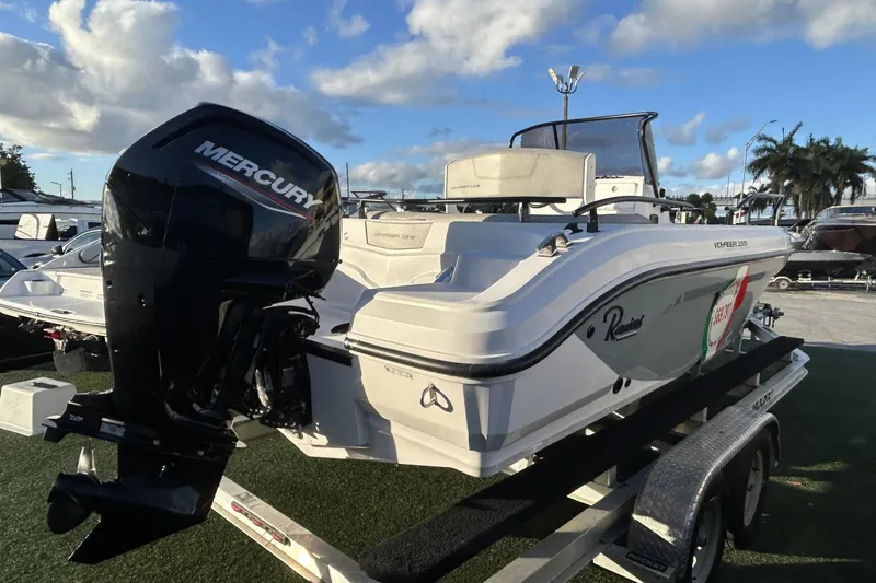 Slide: The Image of 2024 Ranieri Voyager 19S boat with Mercury engine on a trailer, under a blue sky. - 24