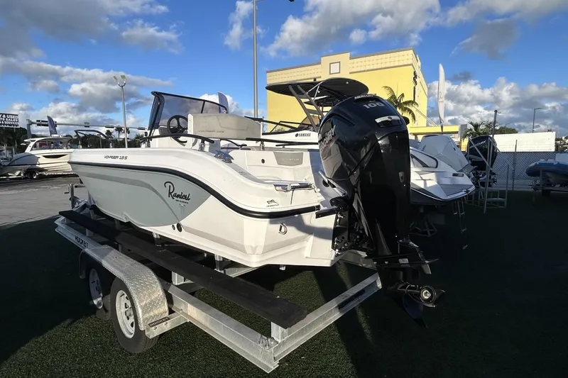 Slide: The Image of 2024 Ranieri Voyager 19S boat on trailer, displayed outdoors under a blue sky. - 26