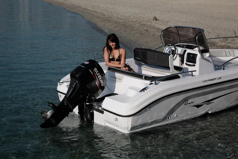 Slide: The Image of 2024 Ranieri Voyager 19S boat cruising on calm water with scenic background. - 3