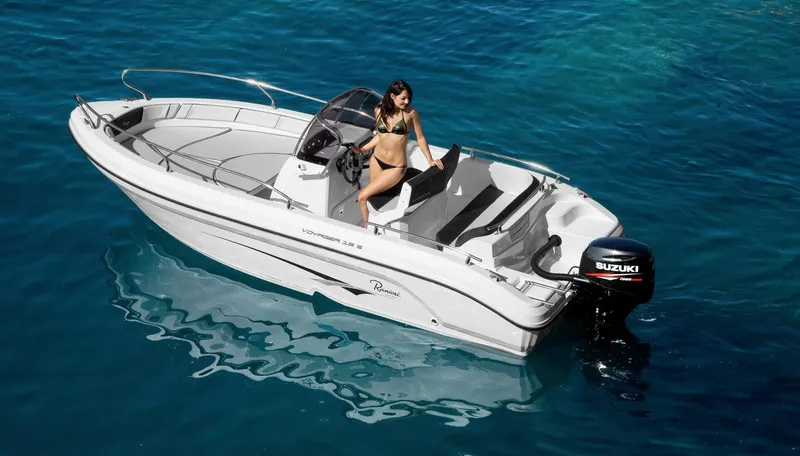 Slide: The Image of 2024 Ranieri Voyager 19S boat with Suzuki engine, woman relaxing onboard near beach. - 5