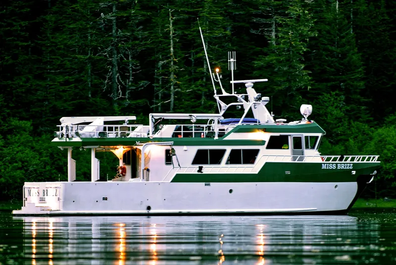 Slide: The Image of Peregrine 62 Custom yacht, 2003 model, anchored on calm water with forest backdrop. - 2