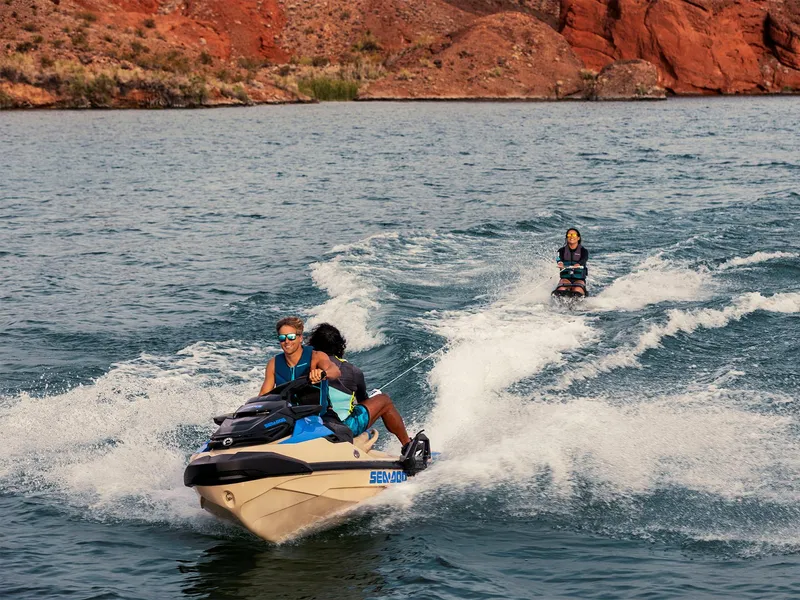 Slide: The Image of 2025 Sea-Doo Wake Pro 230 towing a wakeboarder on a scenic lake. - 15