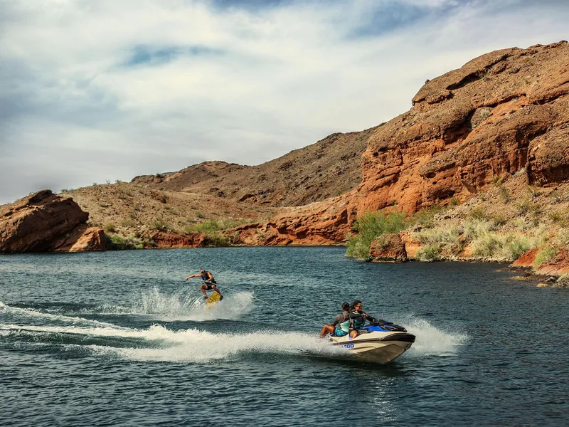 Slide: The Image of 2025 Sea-Doo Wake Pro 230 towing a wakeboarder on a scenic lake. - 18