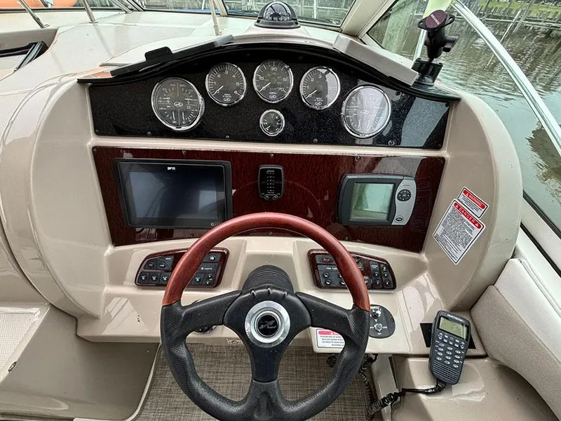 Slide: The Image of 2006 Sea Ray 290 Sundancer dashboard with steering wheel, gauges, and navigation equipment. - 10