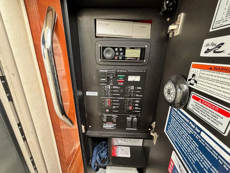 Slide: The Image of Electrical control panel of 2006 Sea Ray 290 Sundancer boat with various switches and warnings. - 18