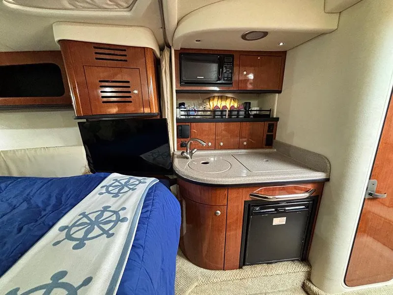 Slide: The Image of 2006 Sea Ray 290 Sundancer cabin with kitchenette, microwave, and bed. - 22