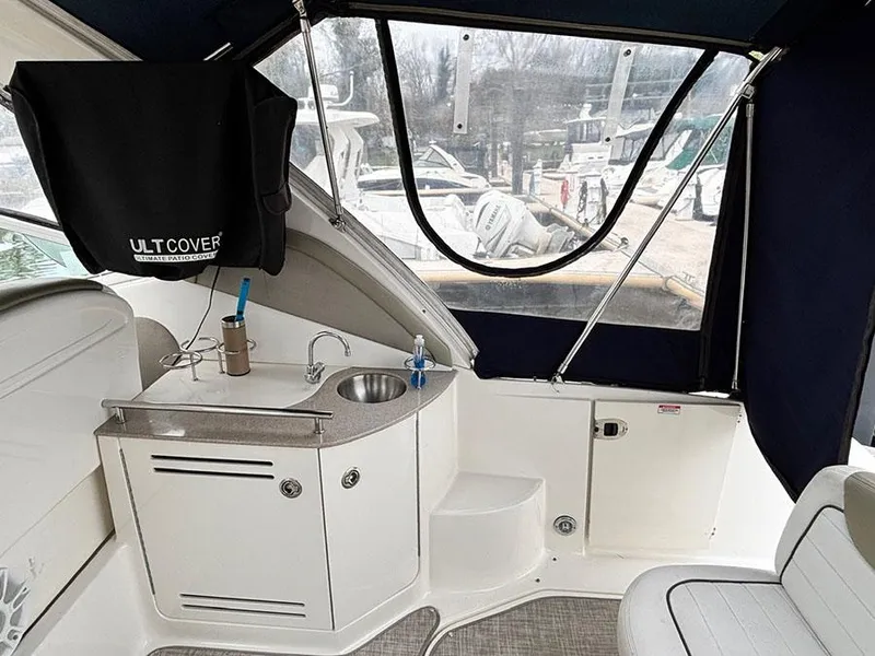Slide: The Image of 2006 Sea Ray 290 Sundancer interior with kitchenette and seating area. - 4