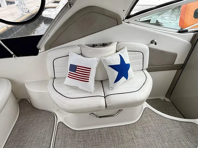 Slide: The Image of Interior of 2006 Sea Ray 290 Sundancer with patriotic-themed cushions on white seating. - 6