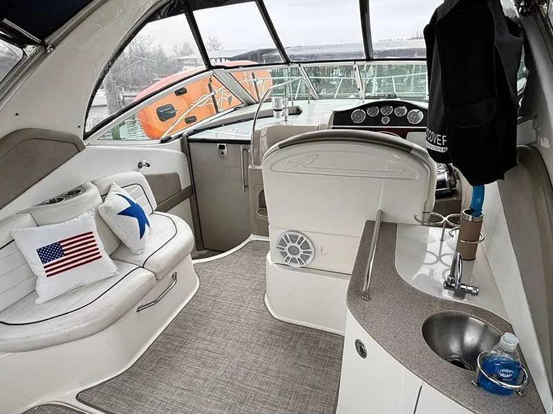 Slide: The Image of 2006 Sea Ray 290 Sundancer interior with seating, helm, and kitchenette. - 7
