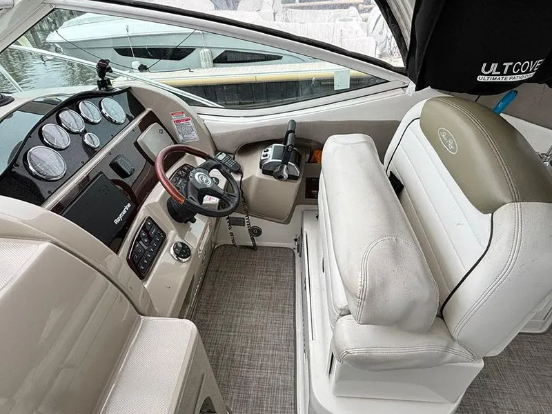 Slide: The Image of 2006 Sea Ray 290 Sundancer helm with gauges, steering wheel, and comfortable seating. - 8