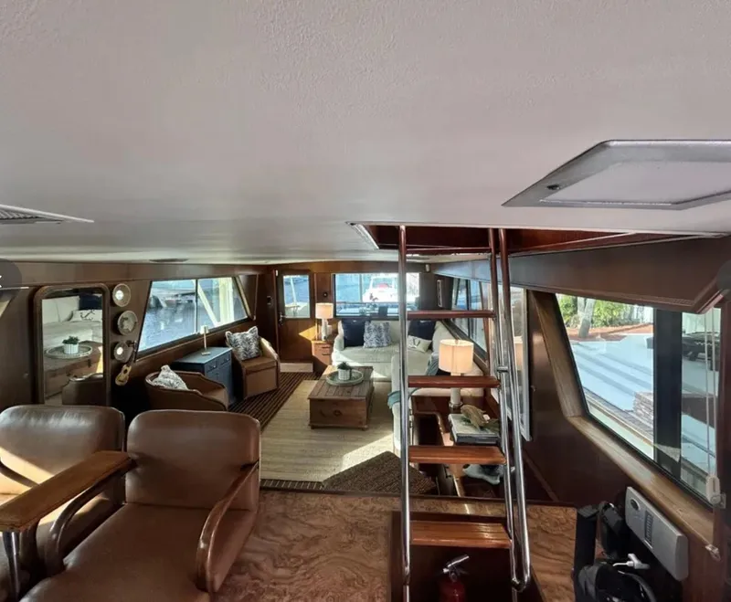 Slide: The Image of Interior of 1989 Hatteras 67 Cockpit Motor Yacht, featuring spacious seating and elegant wood finishes. - 9