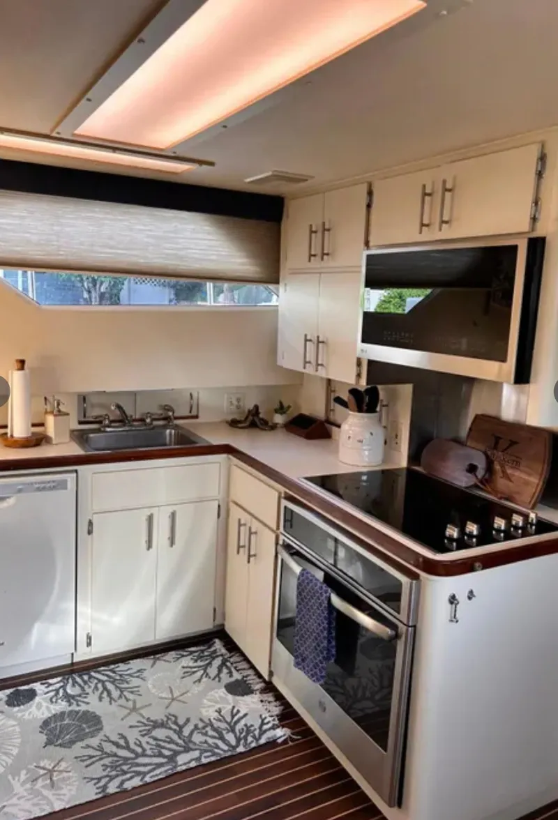 Slide: The Image of 1989 Hatteras 67 Cockpit Motor Yacht kitchen with modern appliances and wood accents. - 12